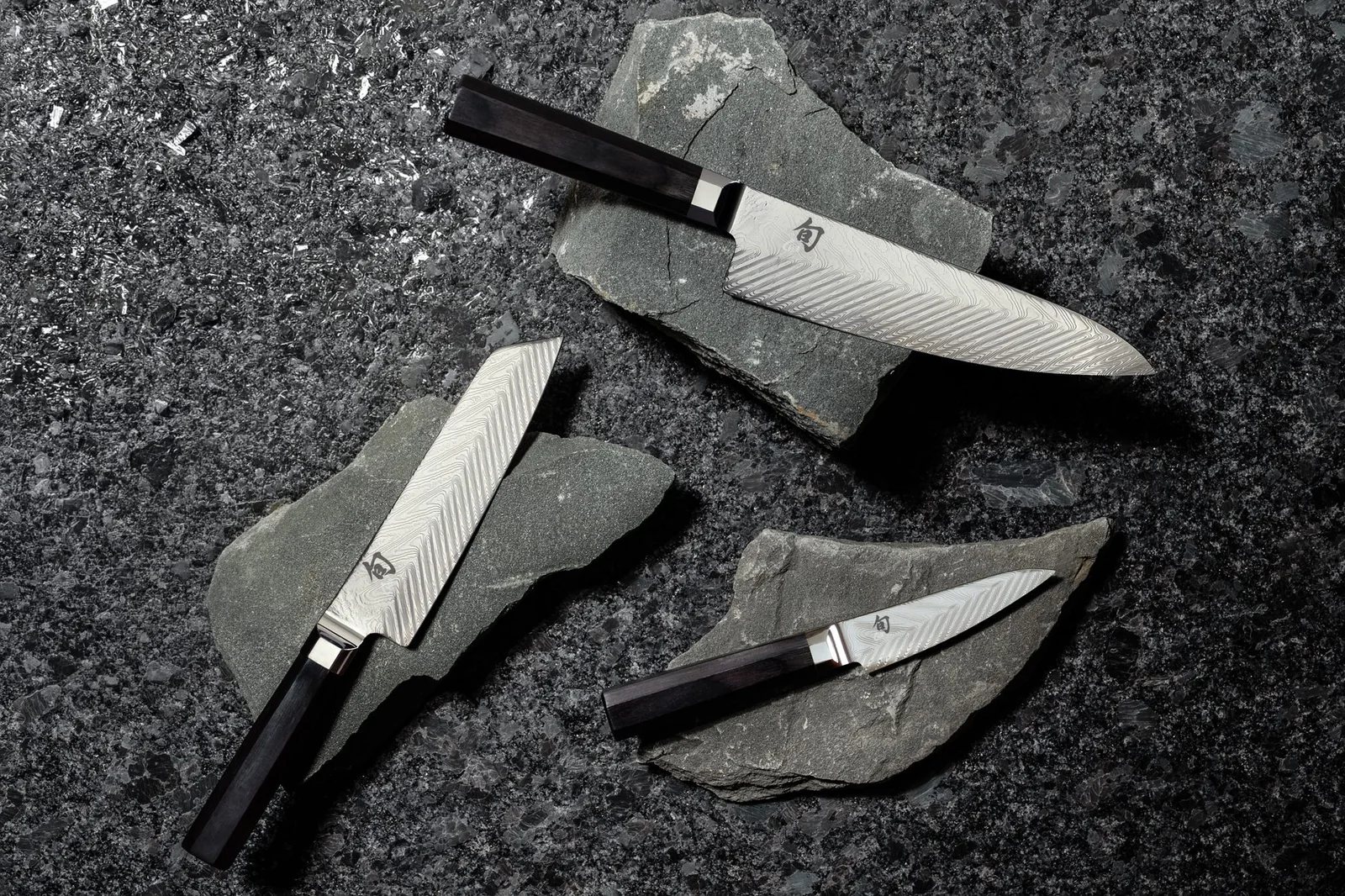 Shun Dual Core knives laid out in a row beside their sayas