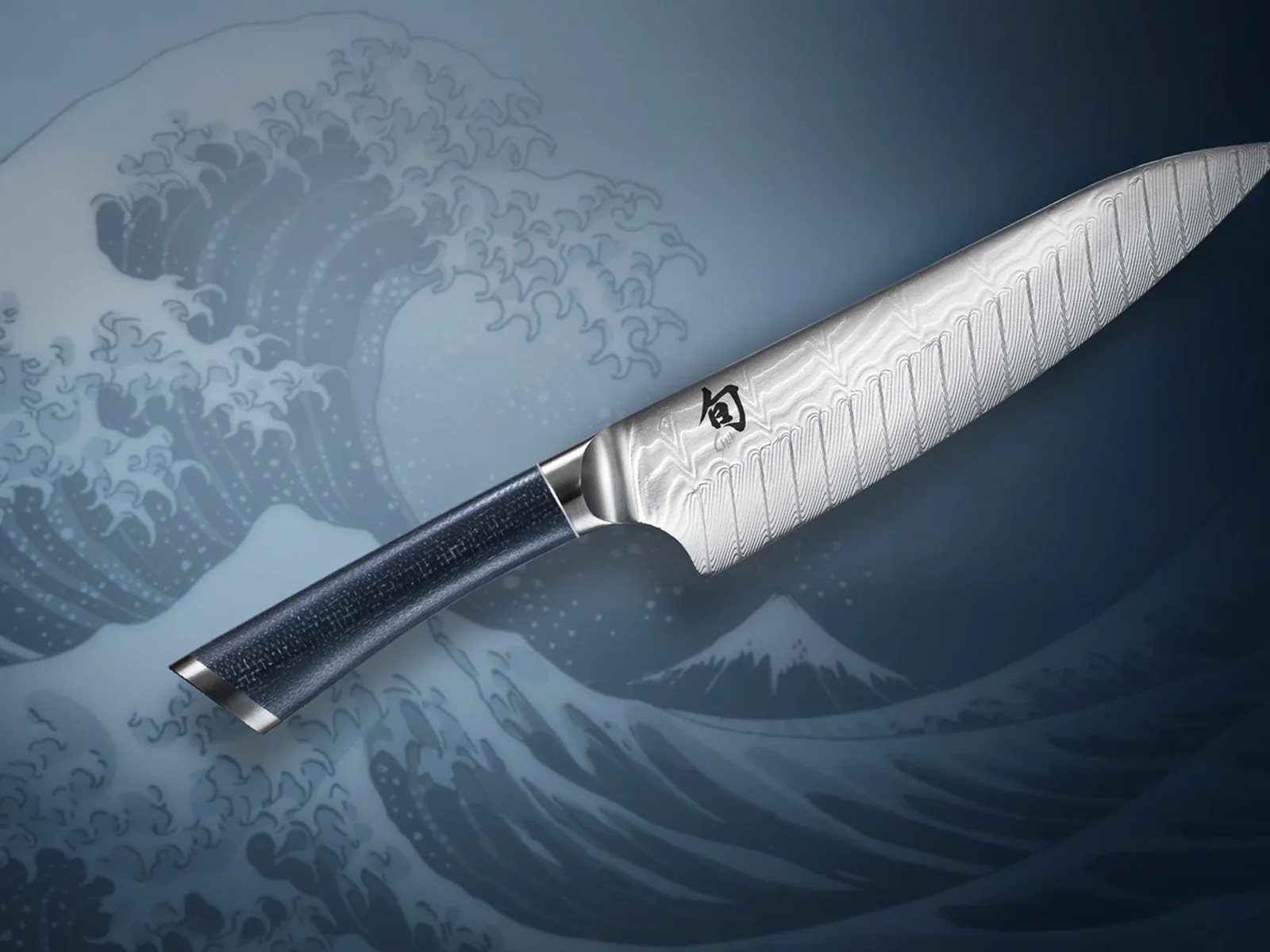 Shun Shiranami chef’s knife with wave Damascus blade against a Japanese wave illustration